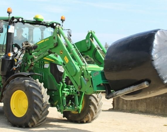 Tractor with wrapped hay bales